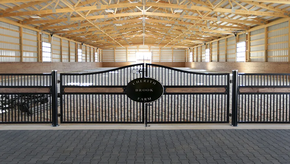 Post-frame indoor horse arena with custom gate