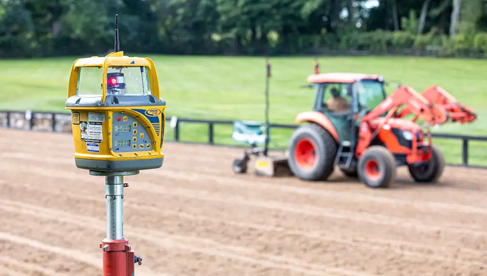 Close Up of arena laser device with grader on the tractor.